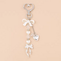 Keychain with bow and heart charm on a beige background