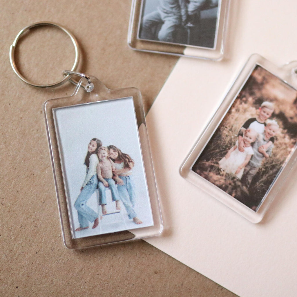 Keychain with a photo of a family on a beige surface
